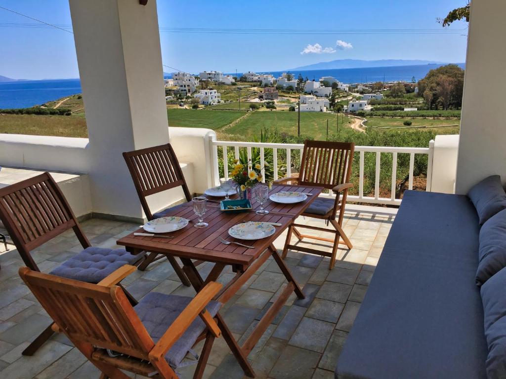 einen Tisch und Stühle auf einem Balkon mit Meerblick in der Unterkunft Anthoula's Sea View Apartment in Piso Livadi