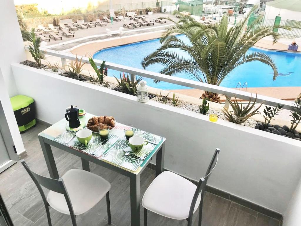una mesa y sillas en un balcón con piscina en Playa del Ingles terrace pool View 207, en San Bartolomé
