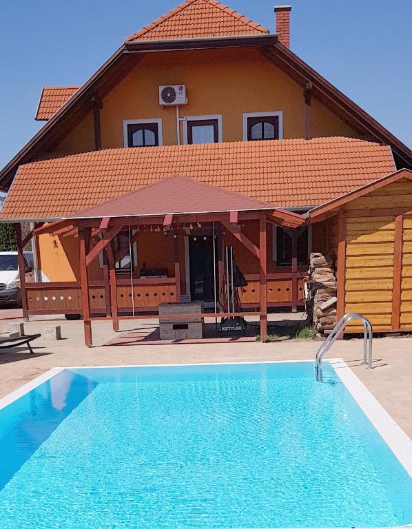 a house with a swimming pool in front of a house at Lifestyle Balaton in Siófok