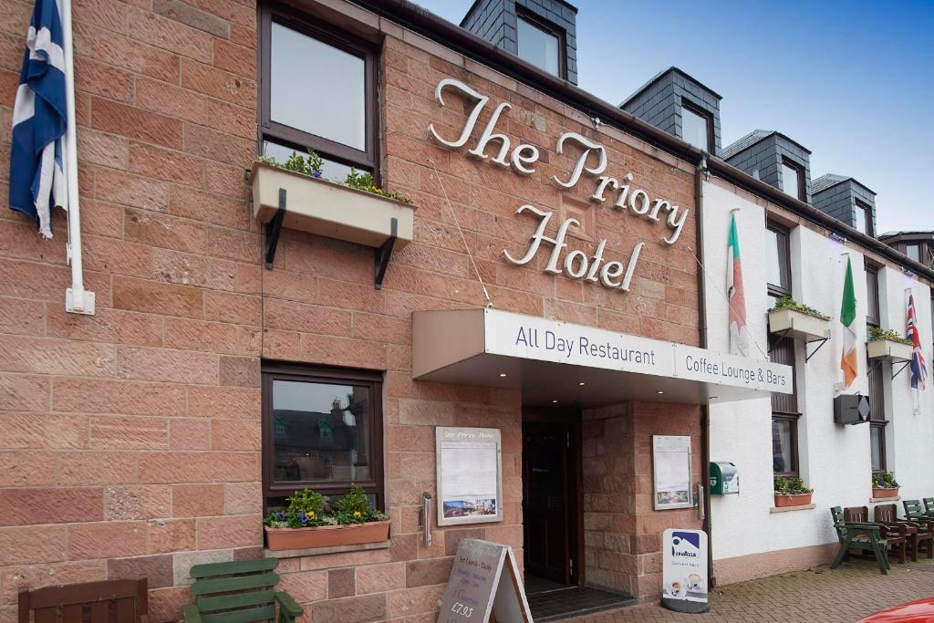 um edifício com uma placa que lê o hotel priory em The Priory Hotel em Beauly