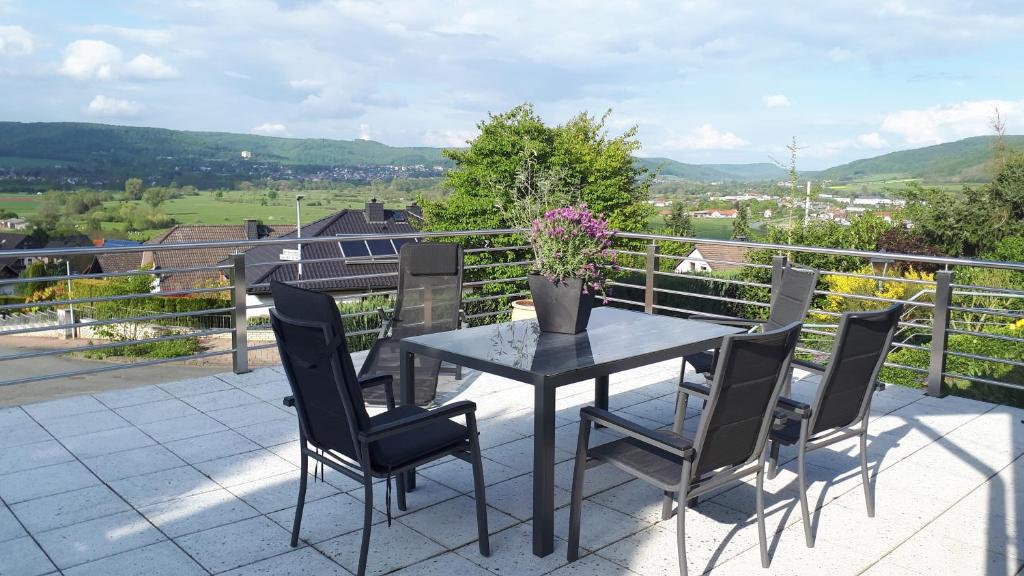 stół z krzesłami oraz waza z kwiatami na balkonie w obiekcie FEWO Zum Golfplatz w mieście Lügde