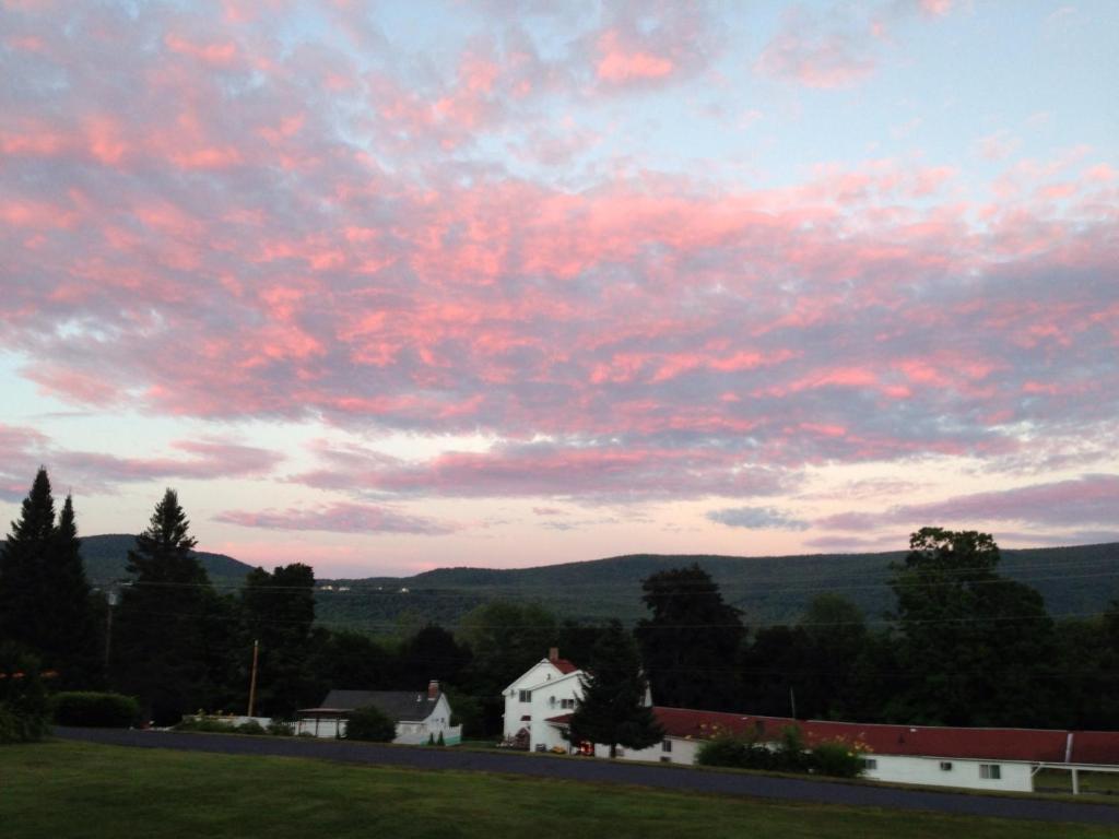 a cloudy sky with a house in a field at Four Winds Country Motel in Manchester