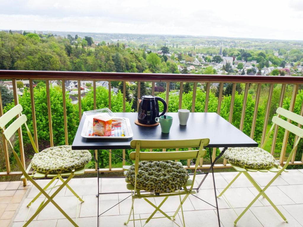 una mesa y sillas en un balcón con vistas en 2 Pieces proche Beauval et Châteaux en Montrichard