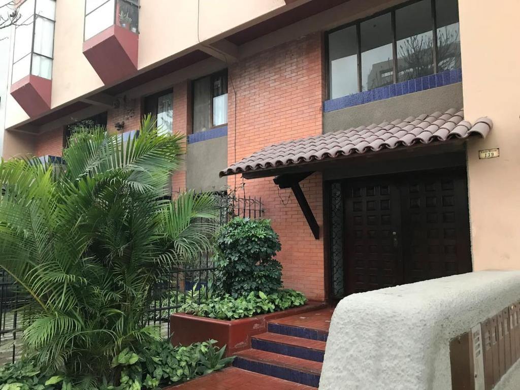 una casa con una puerta negra y algunas plantas en Tezza Apartment two blocks from the American Embassy, en Lima