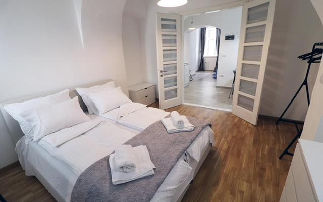 a bedroom with a large white bed with towels on it at Apartman Tina in Novi Sad