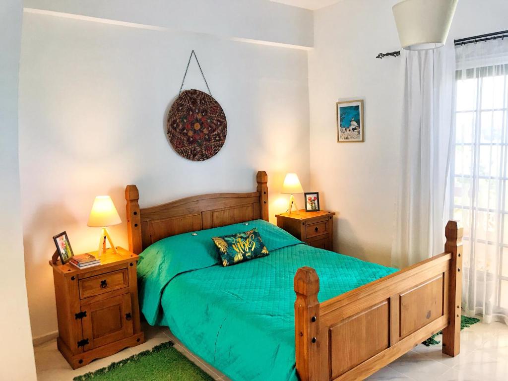 ein Schlafzimmer mit einem Holzbett und zwei Nachttischen in der Unterkunft Tina’s Cozy Studio in Polis Chrysochous
