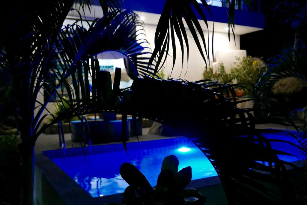 a dark room with a swimming pool with plants at Sky Villas Paris With beautiful sea views in Laem Set Beach