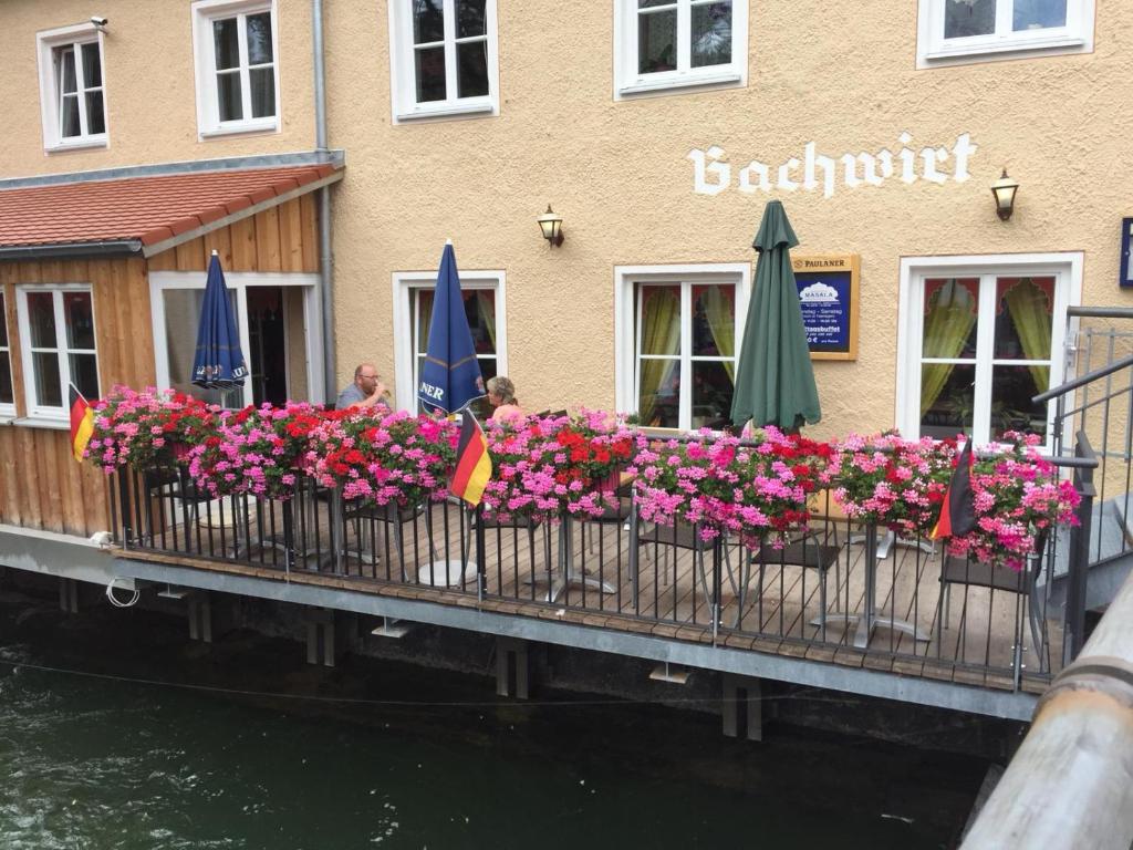 a balcony with flowers and umbrellas in front of a building at Gästehaus Sarker in Landsberg am Lech