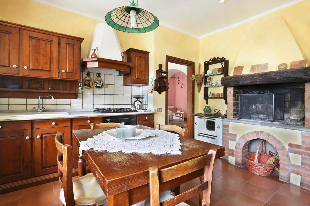 eine Küche mit einem Tisch und einem Kamin in der Unterkunft Chiantihouse near Florence in Montespertoli