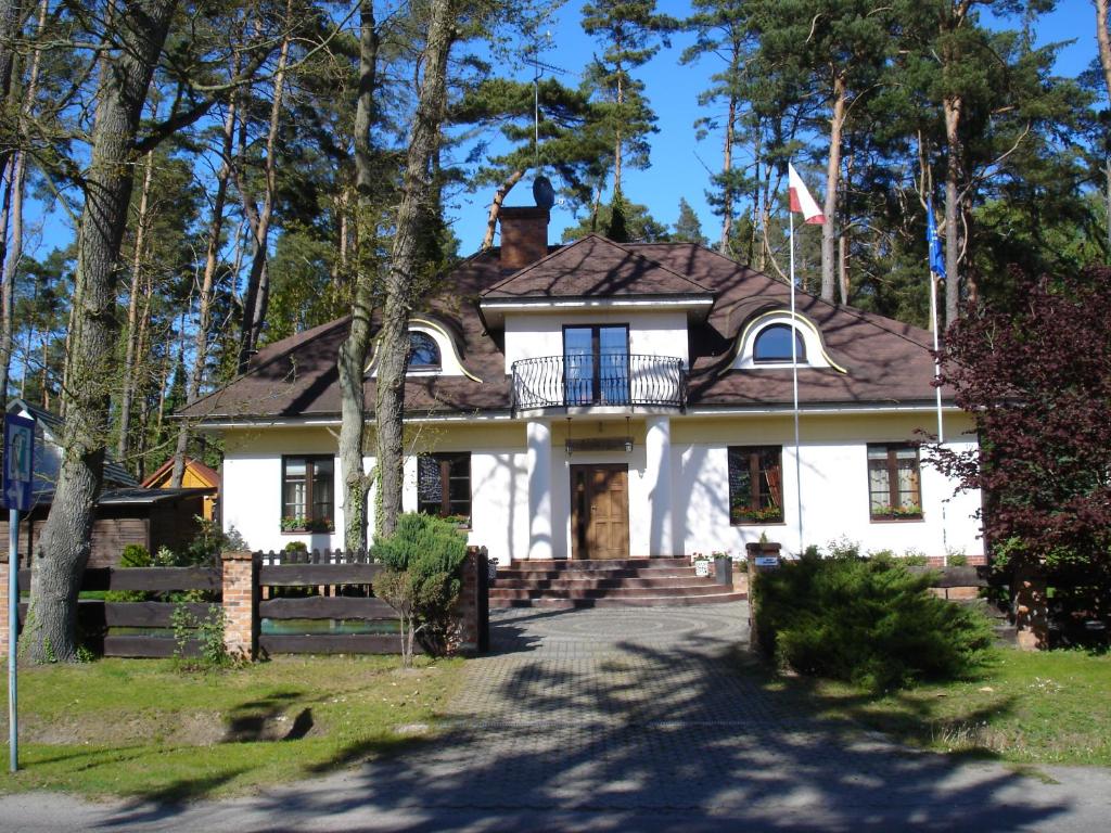 a white house with a flag in front of it at Gościnny Dworek in Pobierowo