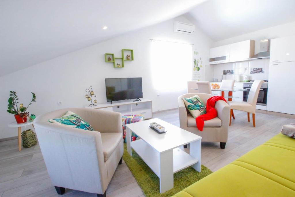 ein Wohnzimmer mit 2 Stühlen und einem TV in der Unterkunft Studio Apartman Sky in Rovinj