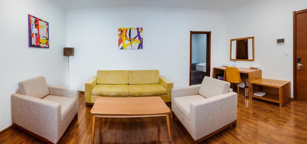 ein Wohnzimmer mit 2 Stühlen und einem Sofa in der Unterkunft Dormitory Hualing Tbilisi in Tbilisi City