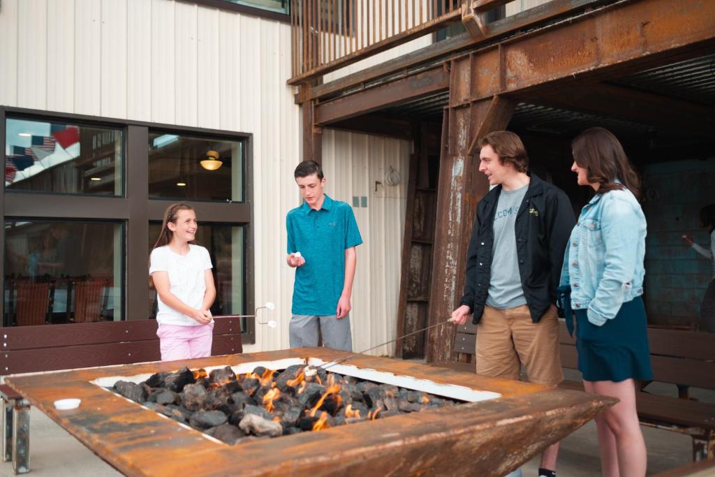 eine Gruppe von Menschen, die um eine Feuerstelle stehen in der Unterkunft Iron Springs Luxury Lodge & Spa in Cedar City