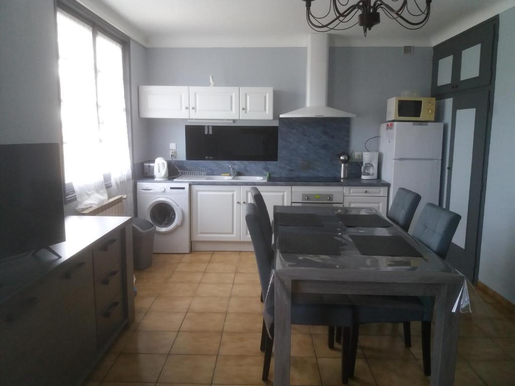 a kitchen with a table and chairs and a kitchen with a refrigerator at Villa Rue Gainekoa in Cambo-les-Bains
