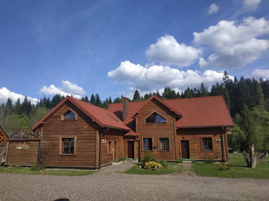 a large wooden house with a red roof at Magellan in Cisna