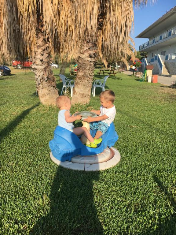 two young boys riding on a toy train at Seaview Aparthotel in Nea Potidaea