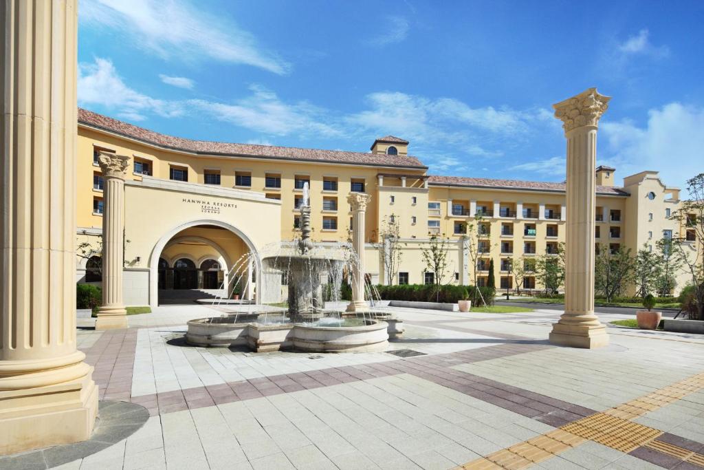 a large building with a fountain in the courtyard at Hanwha Resort Seorak Sorano in Sokcho