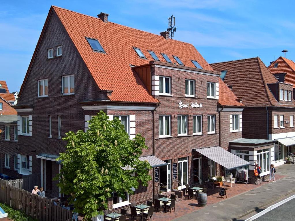 un bâtiment avec un toit orange dans une rue dans l'établissement Haus Worch, à Juist