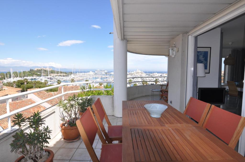 d'un balcon avec une table et des chaises en bois. dans l'établissement Stunning 2-bedroom apartment & panoramic sea view -StayInAntibes- 54 Soleau, à Antibes