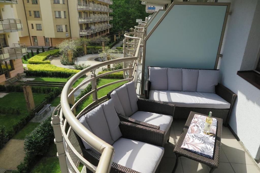 a balcony with chairs and a table on a building at Apartament Opal Zdrojowa 300m do morza in Świnoujście
