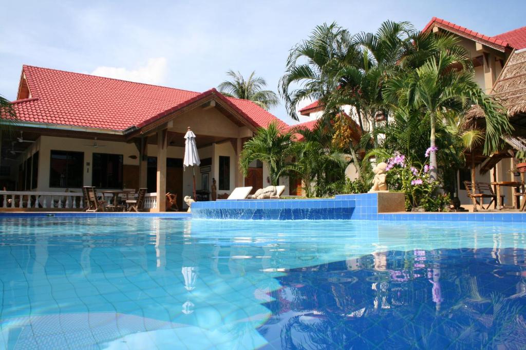 a swimming pool in front of a house at Long Beach Inn in Sam Roi Yot