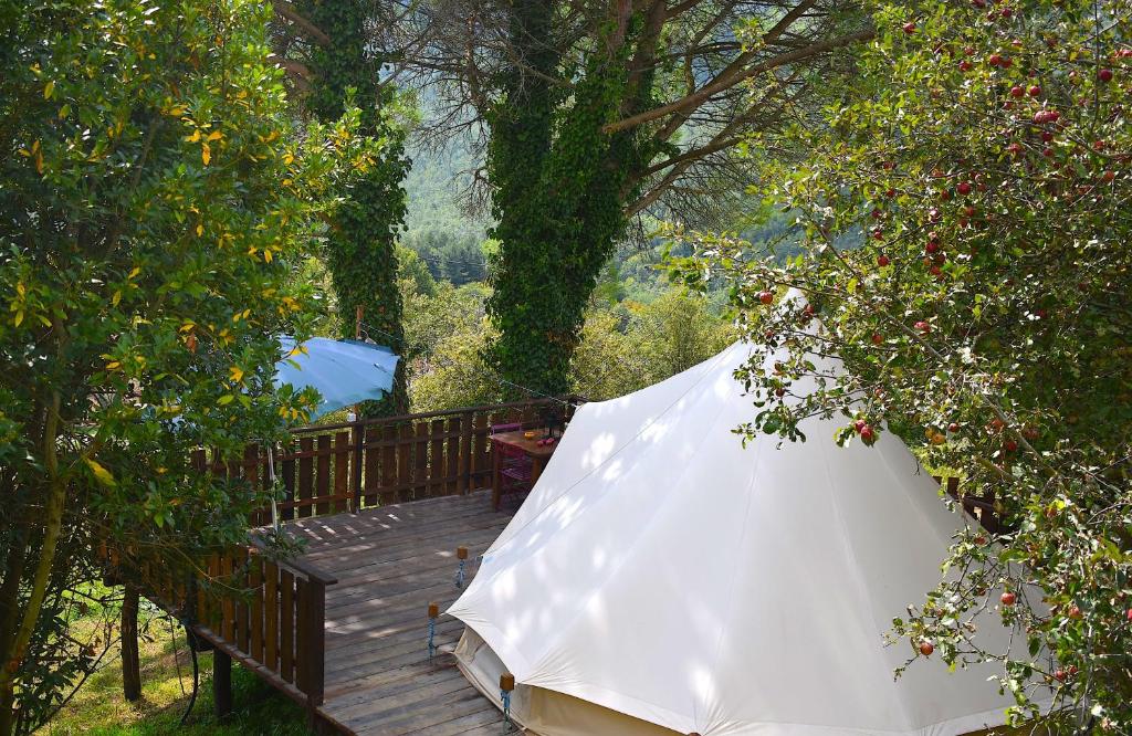 una sombrilla blanca en una terraza de madera en Podere di Maggio - Glamping tent 4, en Santa Fiora