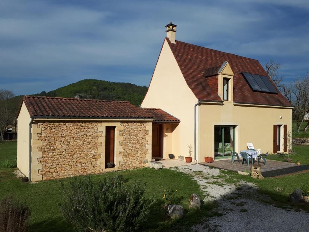 una pequeña casa blanca con techo solar en LOGIS de la CAVE, en Daglan