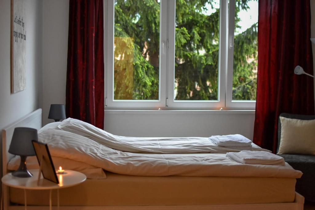 a bed sitting in a room with two windows at White House Sarajevo in Sarajevo