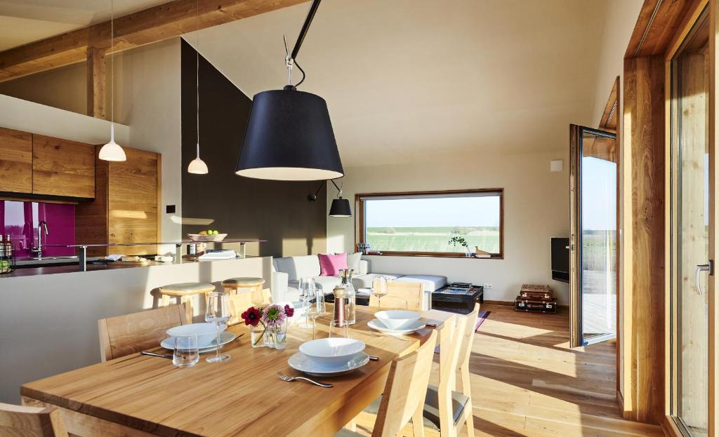 ペルヴォルムにあるGud Jard Lodge Nr 24 - Design-Ferienhaus mit exklusiver Ausstattungのダイニングルーム、キッチン(木製テーブル、椅子付)