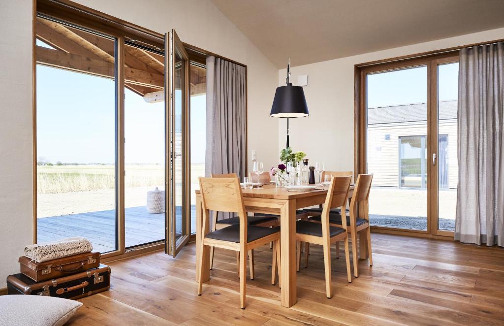 ペルヴォルムにあるGud Jard Lodge Nr 25 - Design-Ferienhaus mit exklusiver Ausstattungのダイニングルーム(木製テーブル、椅子付)