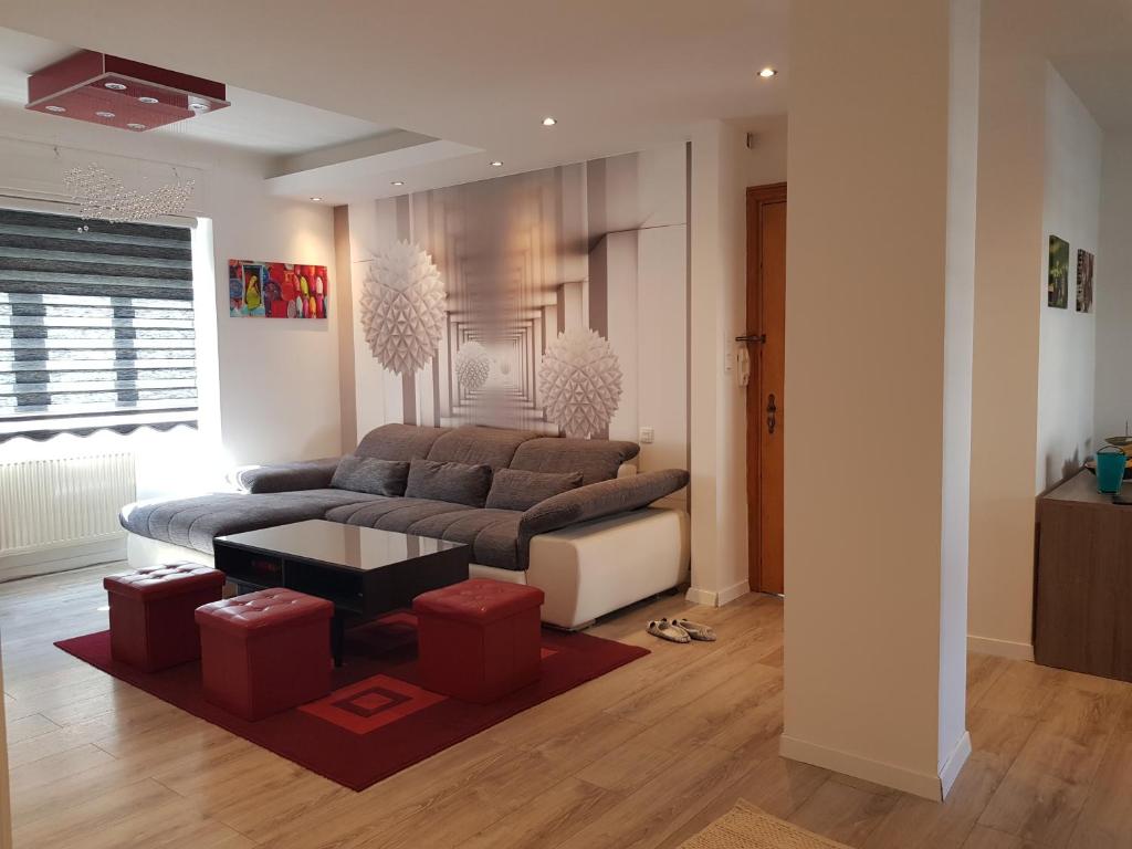 - un salon avec un canapé et des tabourets rouges dans l'établissement le wineck, à Colmar