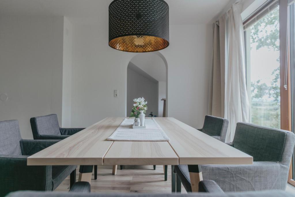 uma sala de jantar com uma mesa de madeira e cadeiras em KRACHER Suite mit Nationalparkblick em Illmitz
