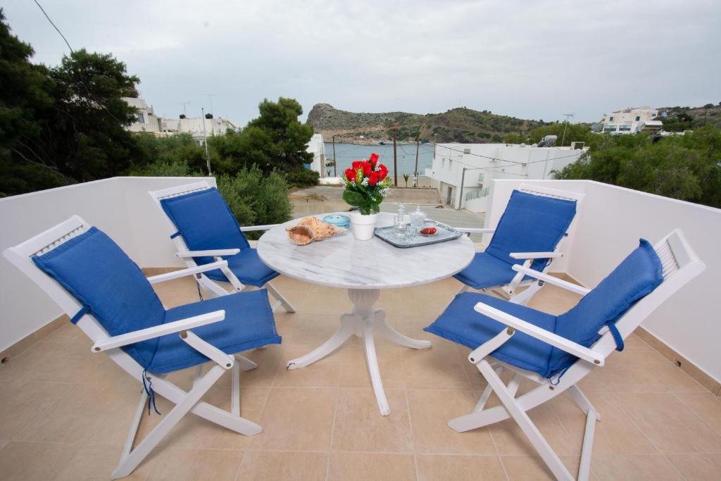 um pátio com uma mesa e 4 cadeiras numa varanda em Seaside Apartments em Kaloí Liménes