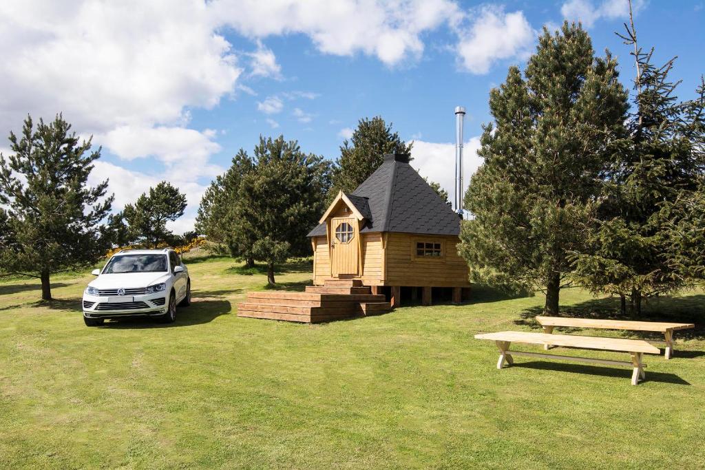 un coche aparcado frente a una casa pequeña en Little Lochan Lodge en Glenfarg