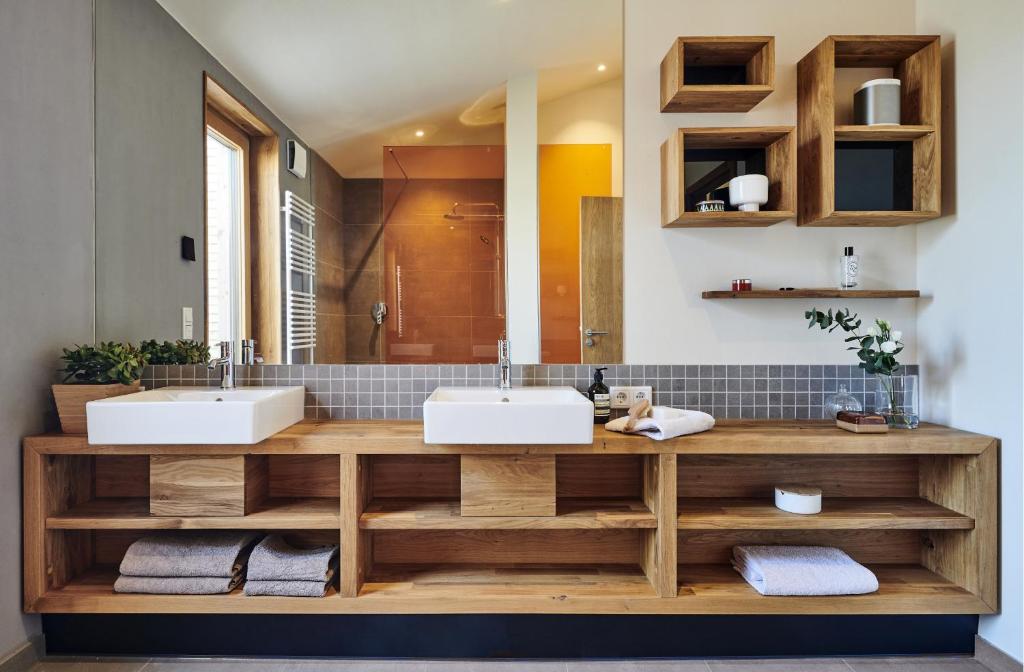 łazienka z 2 umywalkami i dużym lustrem w obiekcie Gud Jard Lodge Nr 28 - Design-Ferienhaus mit exklusiver Ausstattung w mieście Pellworm
