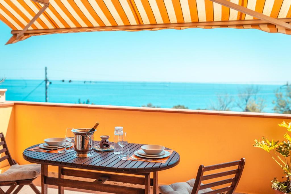 a table on a balcony with a view of the ocean at A due passi da Taormina in Letojanni