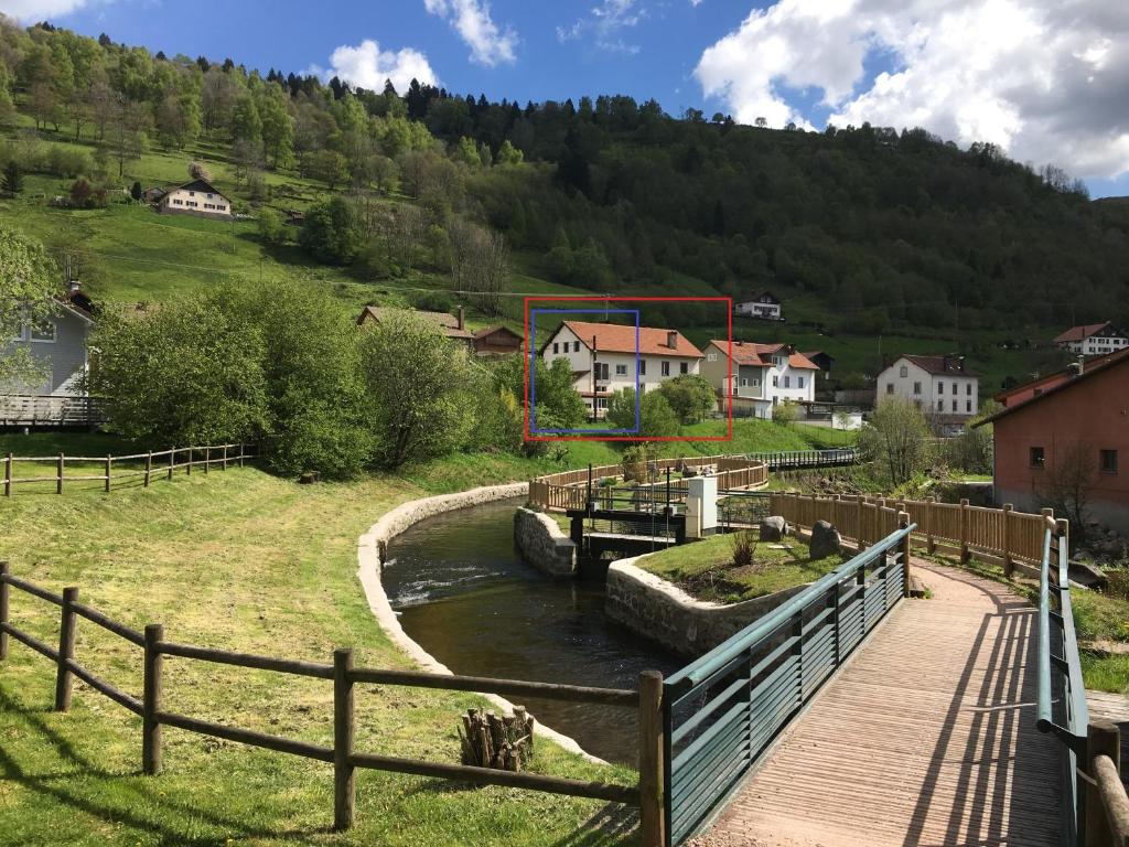 un pont en bois sur une rivière dans un village dans l'établissement La montagne, à La Bresse