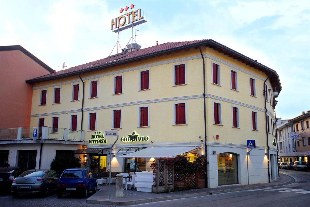 un grande edificio con un cartello hotel sopra di Hotel Vittoria a San Giórgio di Nogaro