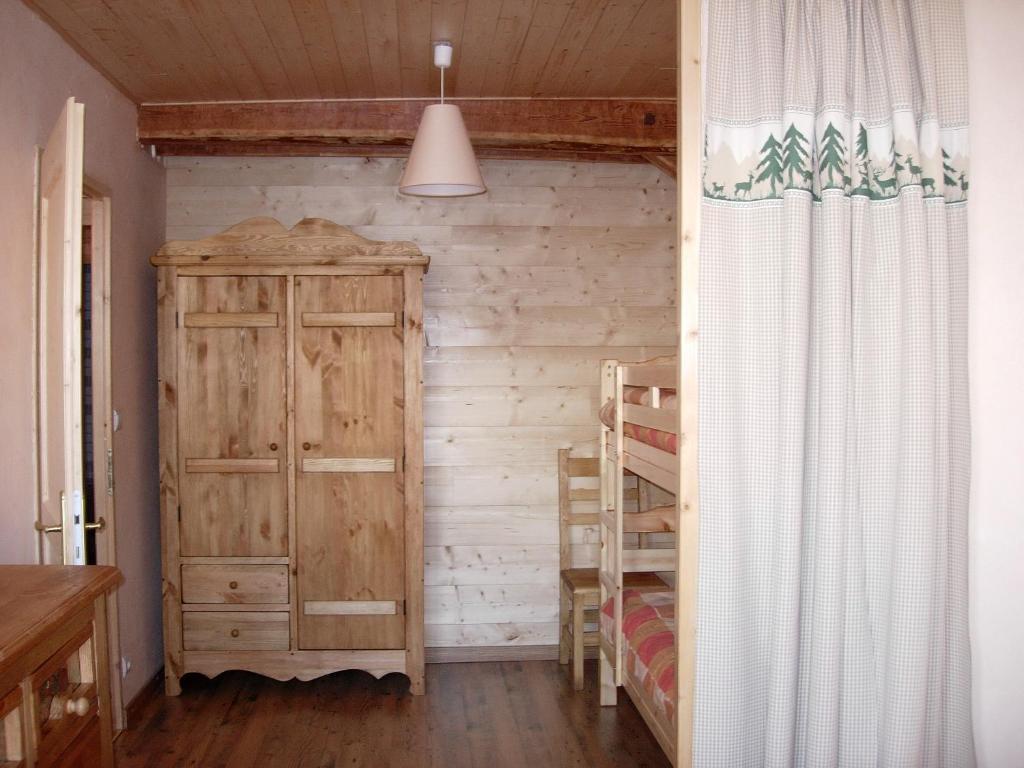 a bedroom with a wooden wall and a bunk bed at BOROT2 in Lanslebourg-Mont-Cenis