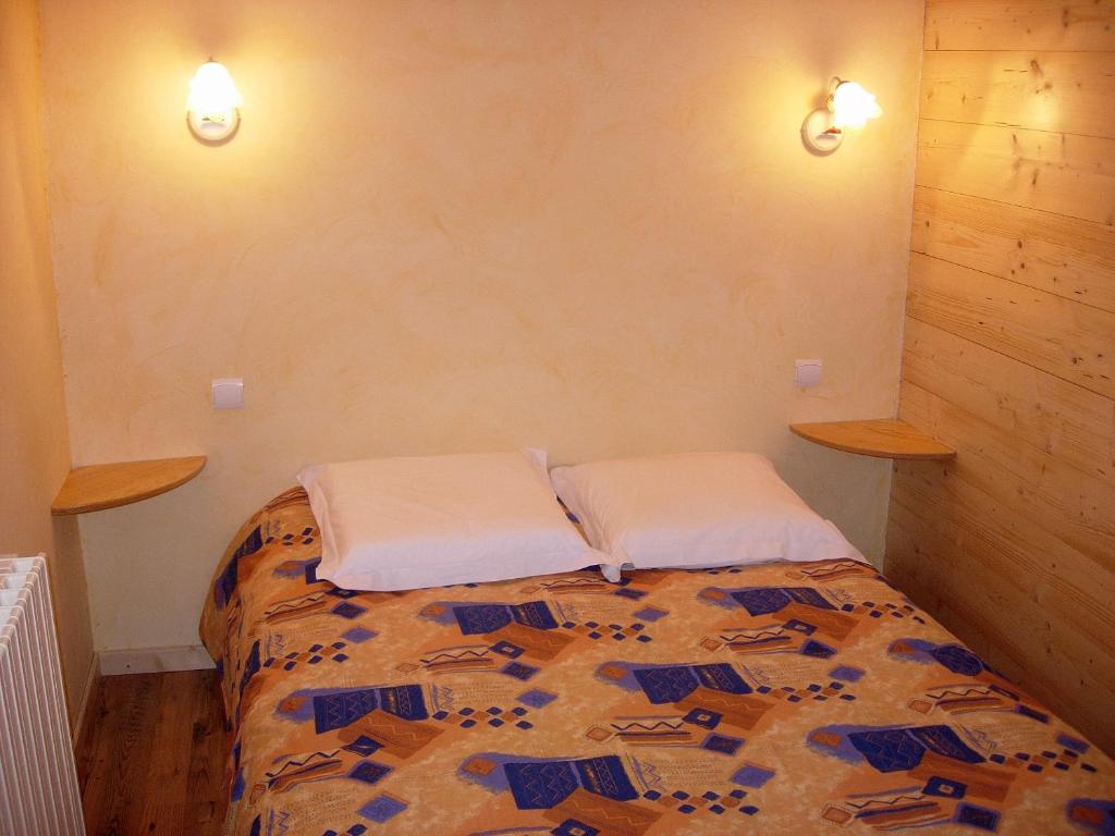 a bedroom with a bed with two pillows on it at BOROT2 in Lanslebourg-Mont-Cenis