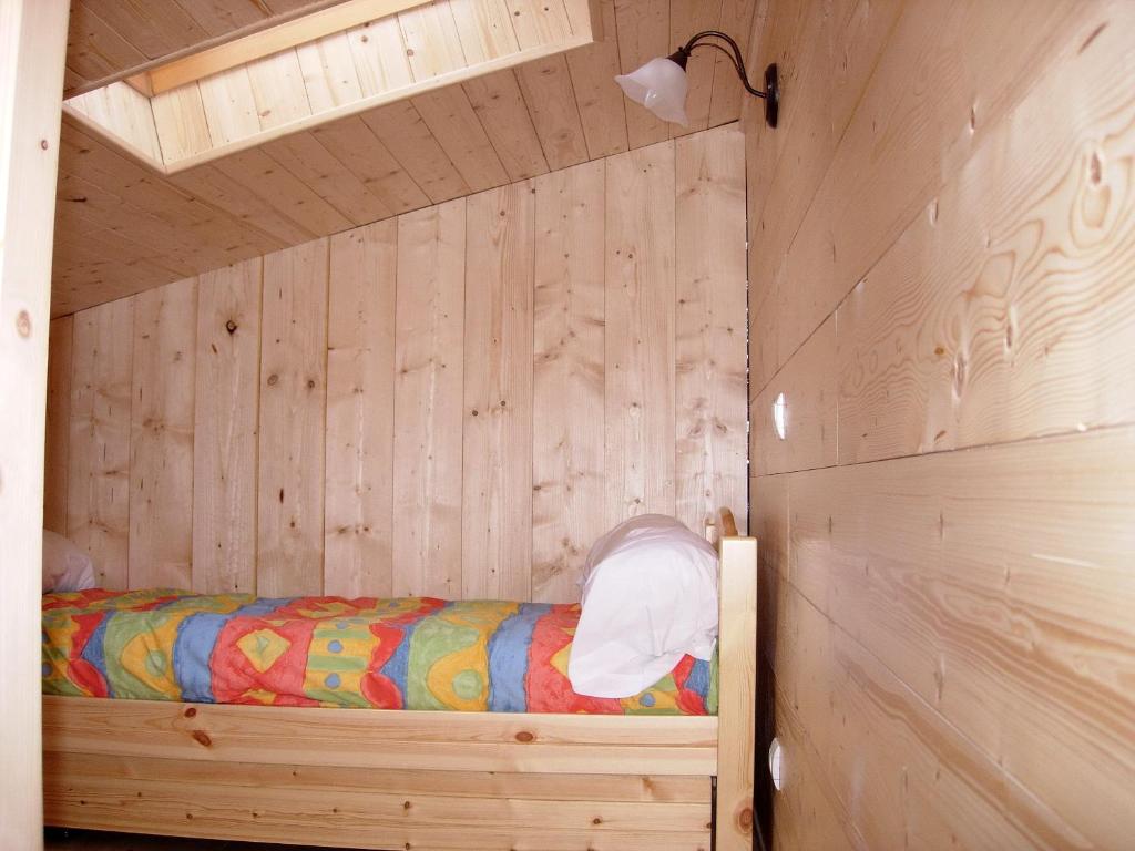 a bedroom with a bed in a wooden wall at BOROT2 in Lanslebourg-Mont-Cenis