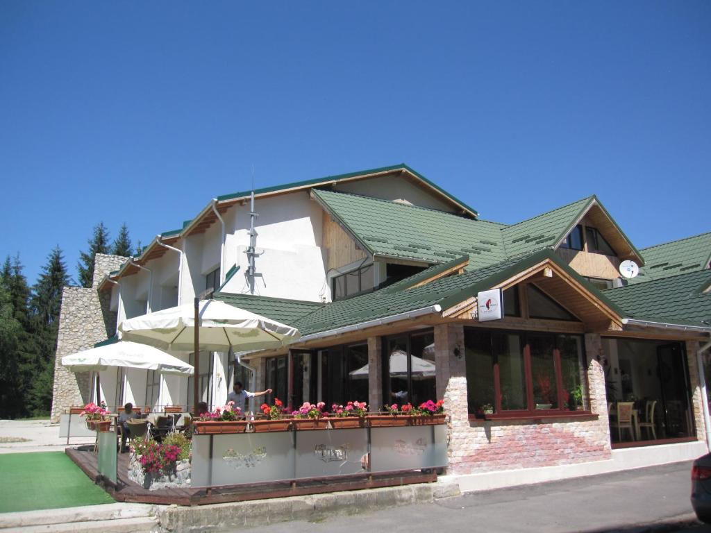 a building with flowers and umbrellas in front of it at Vila Roxy Poiana Brasov in Poiana Brasov