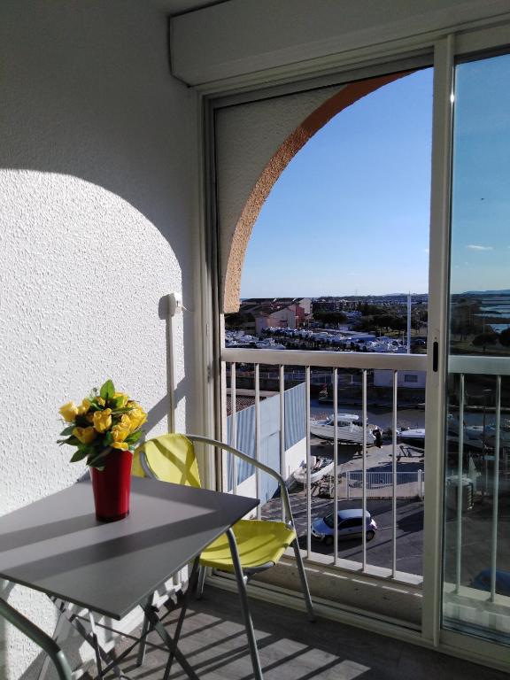 d'une table et de chaises sur un balcon avec vue sur le parking. dans l'établissement Jolis Studios vue sur mer Port, Etangs et Canaux Résidence RIVERCITY, à Carnon-Plage