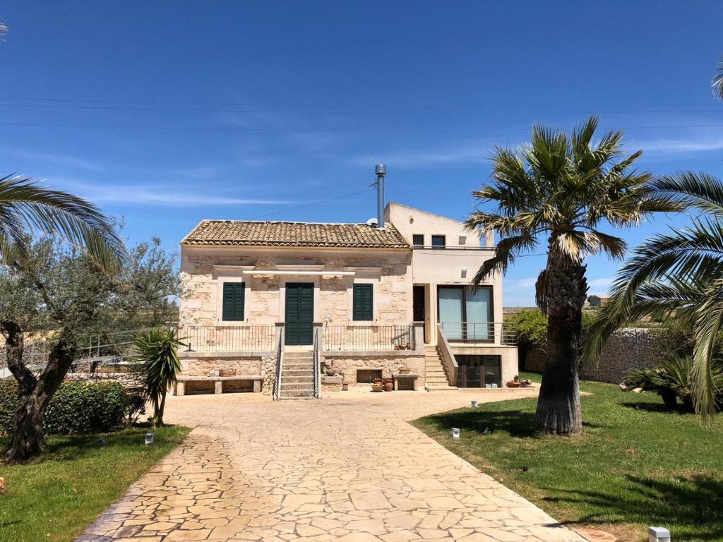 uma casa grande com palmeiras em frente em Le Maria Country Luxury Villa em Ragusa