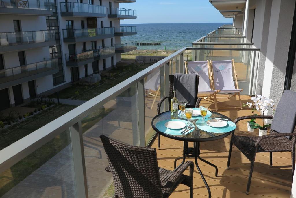 balcone con tavolo, sedie e vista sull'oceano di OPAL z widokiem na morze w Gardenia Sea Side Dziwnów a Dziwnów