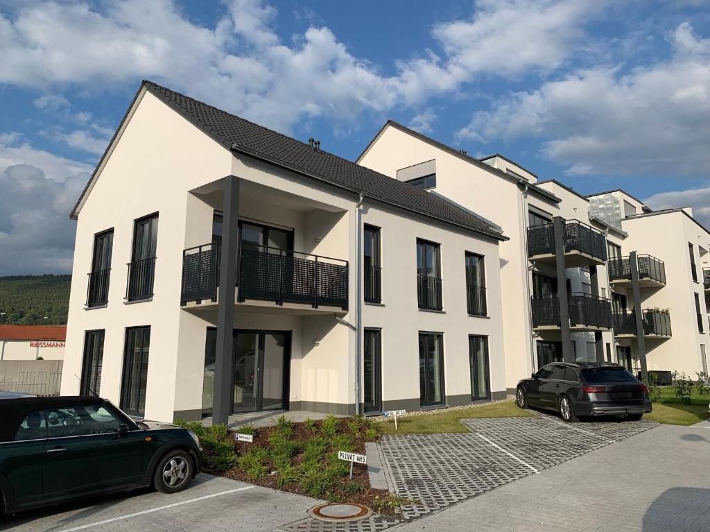 eine Reihe von Häusern mit Autos auf einem Parkplatz in der Unterkunft Main Boarding House in Miltenberg