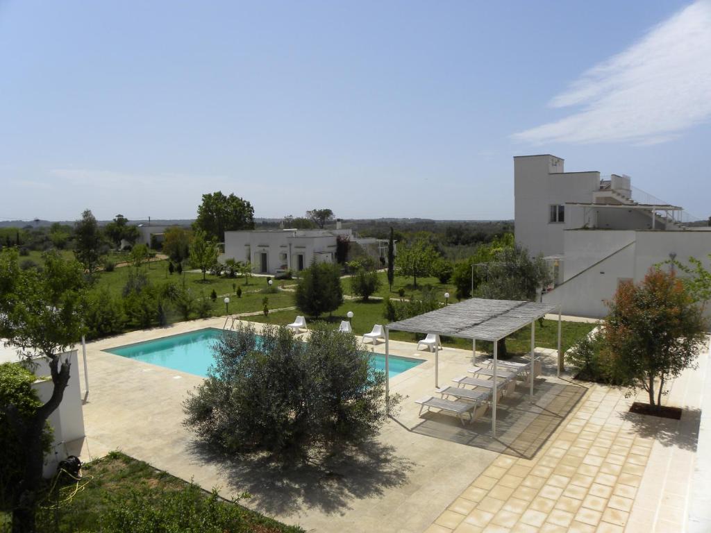 - une vue aérienne sur une piscine en face d'un bâtiment dans l'établissement Masseria Agriturismo Faresalento, à Gallipoli