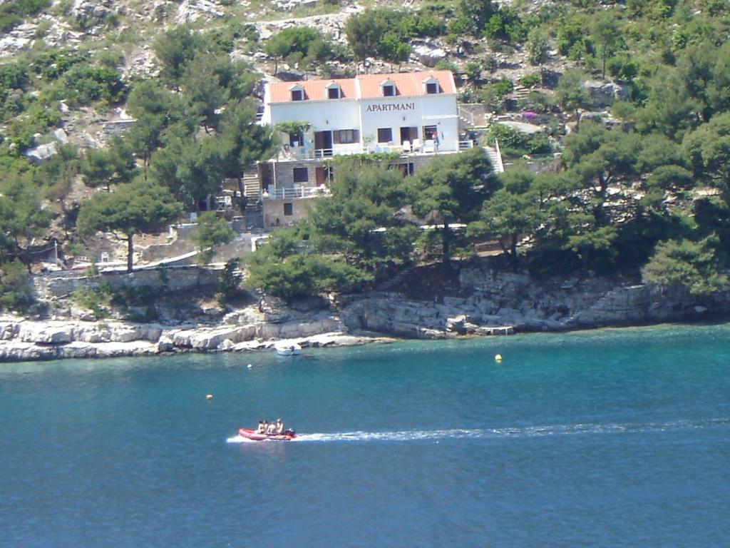 a boat in the water in front of a house at Apartment Josip in Ston