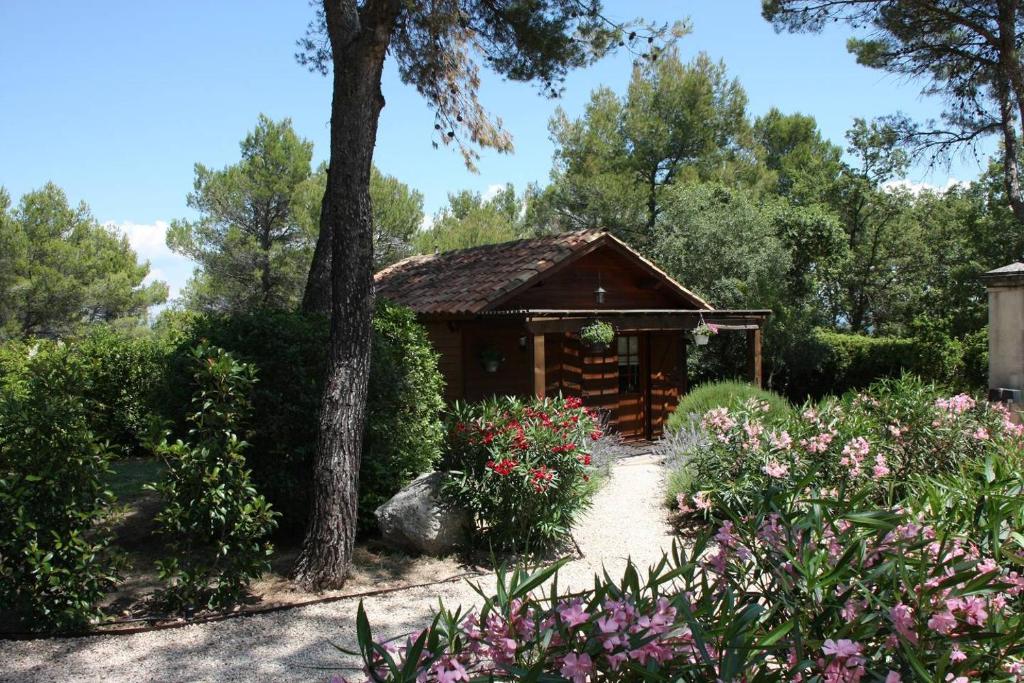 una cabaña de madera en un jardín con flores en Il Sole, en Le Puy-Sainte-Réparade