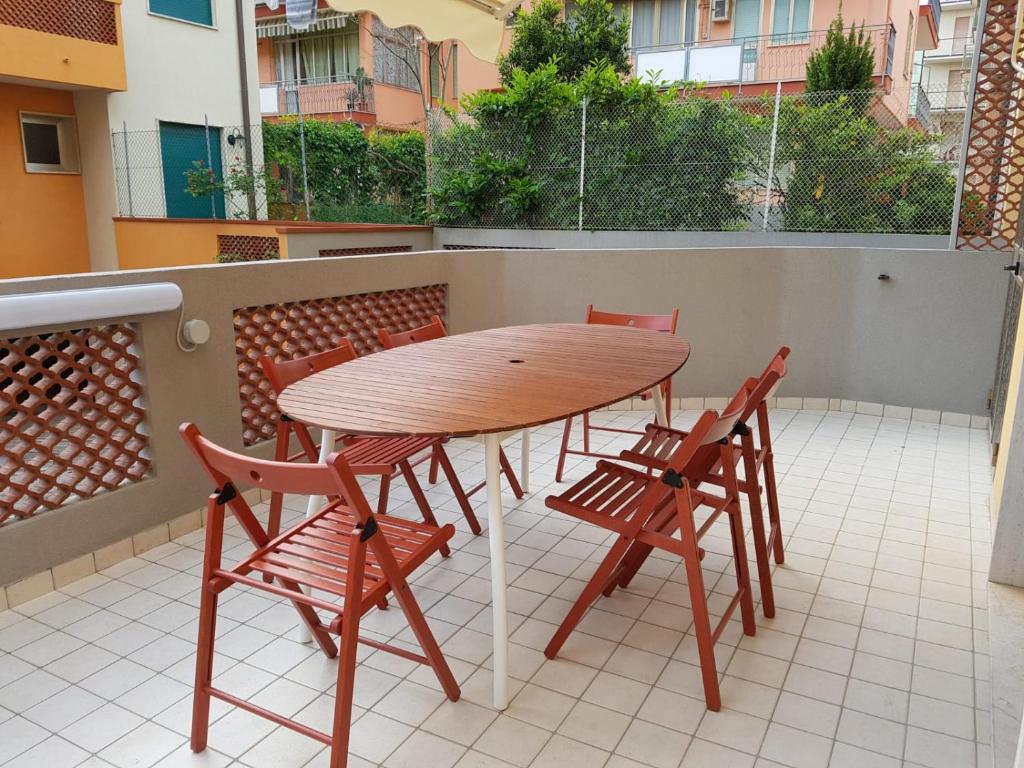 a wooden table and chairs on a balcony at A 3 PASSI DAL MARE in Chioggia